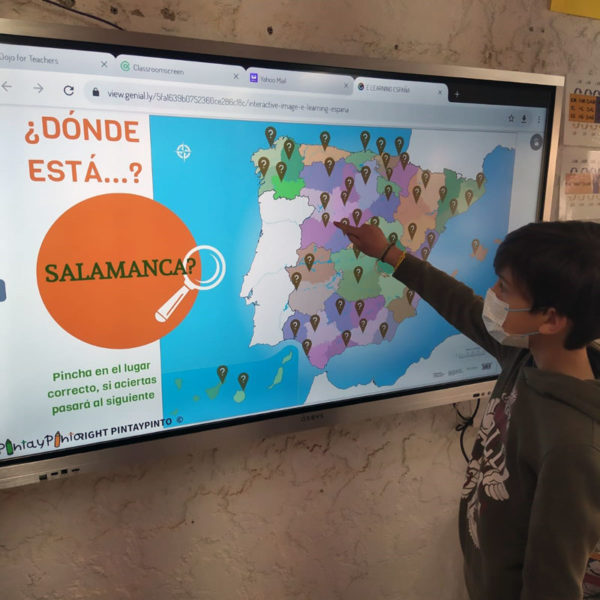 un niño en clase usando un monitor interactivo para jugar a identificar la provincia de Salamanca en el mapa político interactivo de Pinta y Pinto