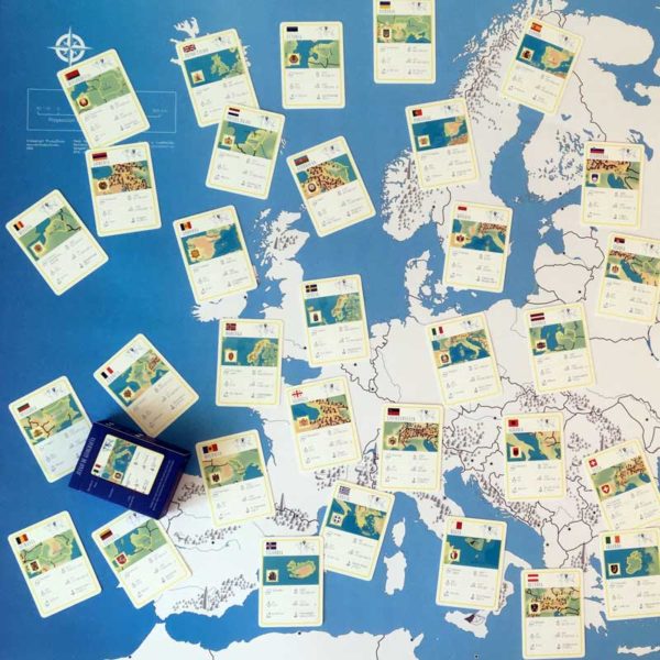 Geography playing cards Geocartas Europe laid out on top of the giant map of Europe.