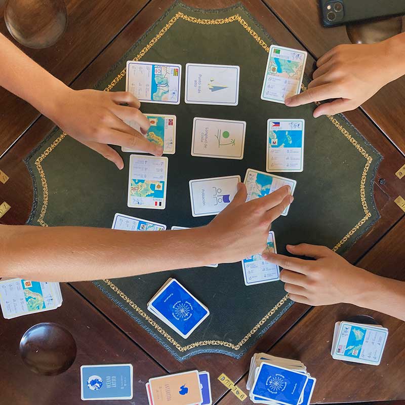 Familia jugando una versión avanzada de Geocartas en una mese de juego.