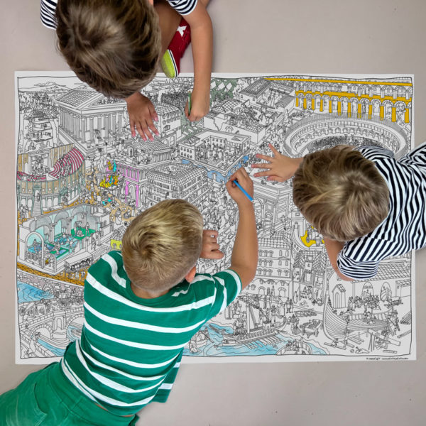 3 niños pintando el mapa del imperio romano en el suelo