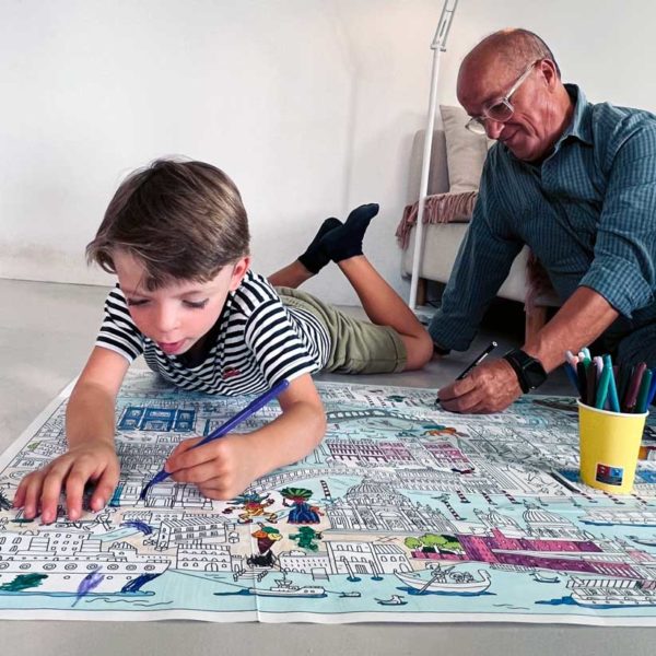 Abuelos y nieto pasando un buen rato juntos coloreando el mapa de Venecia de Pinta y Pinto en el suelo